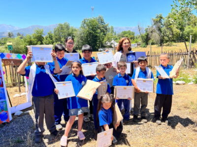 niños y niñas mostrando sus diplomas en evento ambiental de Escuela Corel