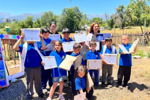 niños y niñas mostrando sus diplomas en evento ambiental de Escuela Corel