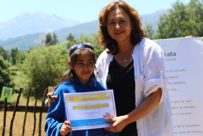 entrega de diploma a niña en evento ambiental de Escuela Corel