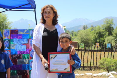 entrega de diploma a niño en evento ambiental de Escuela Corel