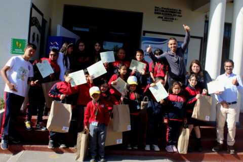 niños y niñas mostrando sus diplomas en Escuela Charrúa